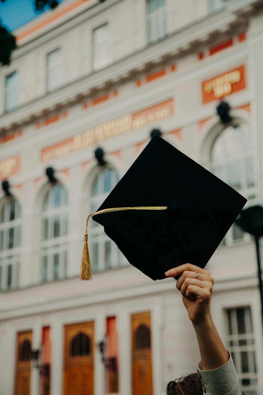 Graduate holding a mortarboard cap outside a university
